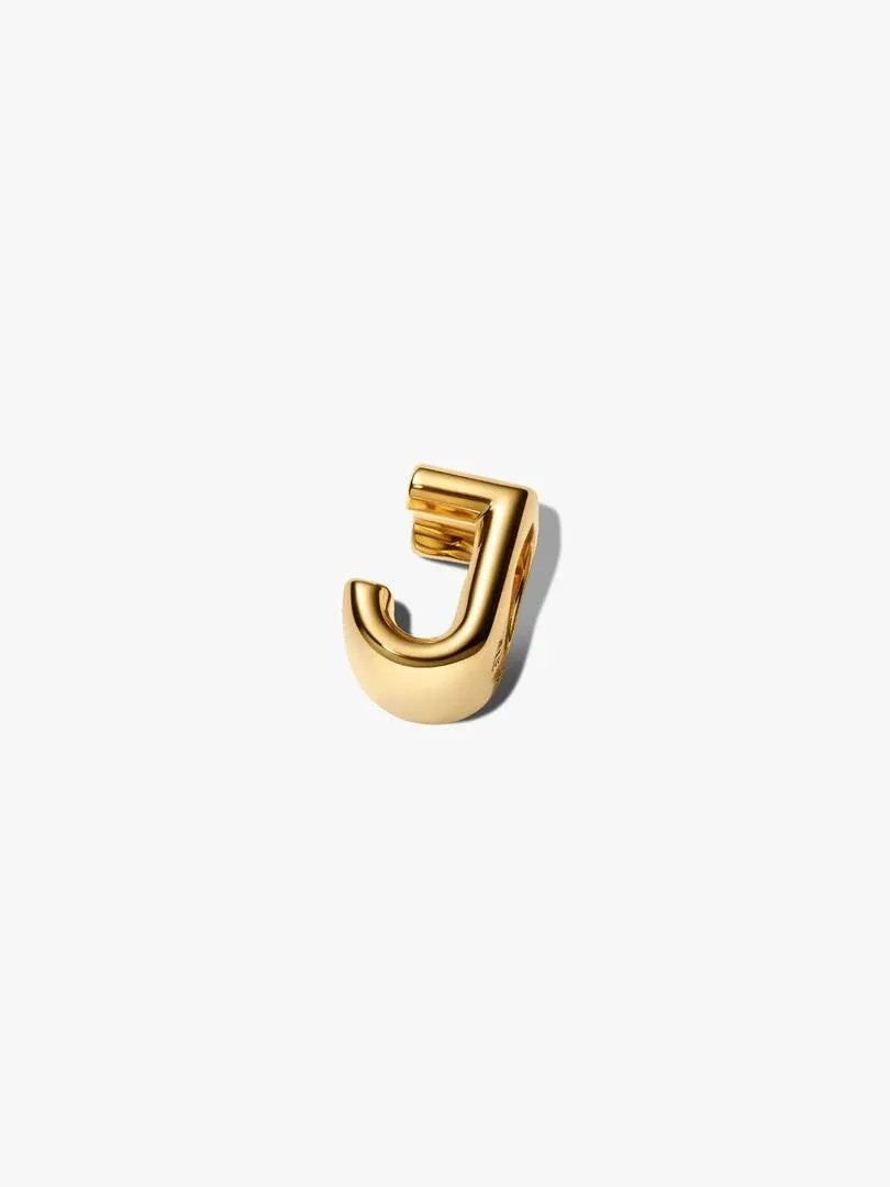 Gouden letter J charm, zijaanzicht vanuit een licht verhoogde hoek op een witte achtergrond.