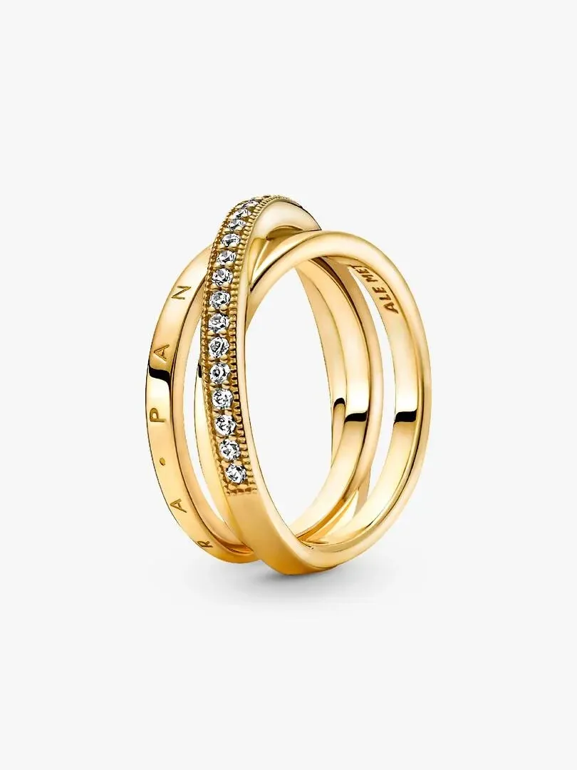 Anillo de tres bandas cruzadas en oro con circonitas, vista lateral en ángulo sobre fondo blanco.