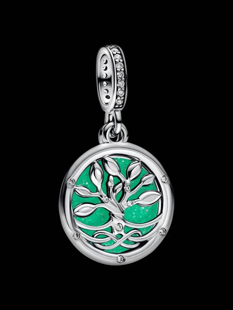Vue frontale d'un pendentif circulaire avec motif d'arbre sur fond noir, prise de vue centrée.