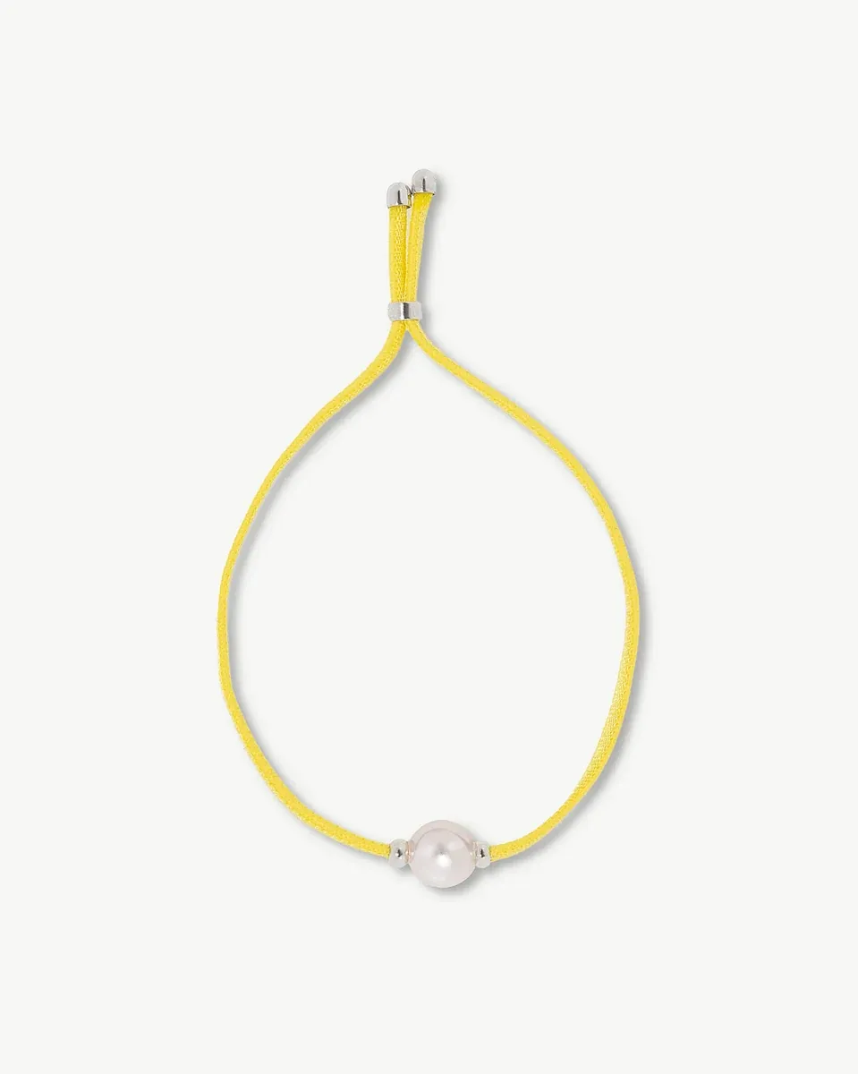 Yellow bracelet top view, white background, featuring the central pearl and adjustable closure.