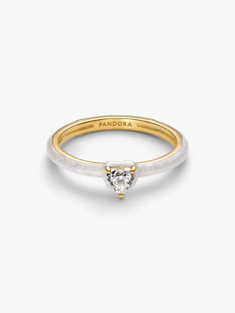 Anillo con gema en forma de corazón visto desde un ángulo lateral, fondo blanco puro.