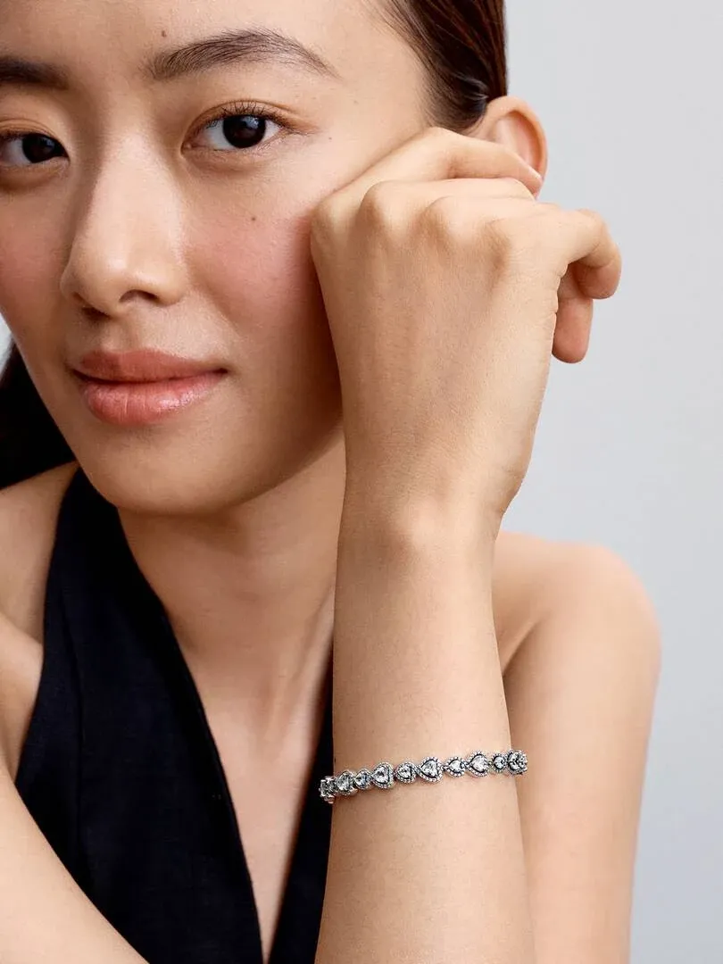 Close-up van de armband om de pols, zijaanzicht met model tegen een lichte neutrale achtergrond.