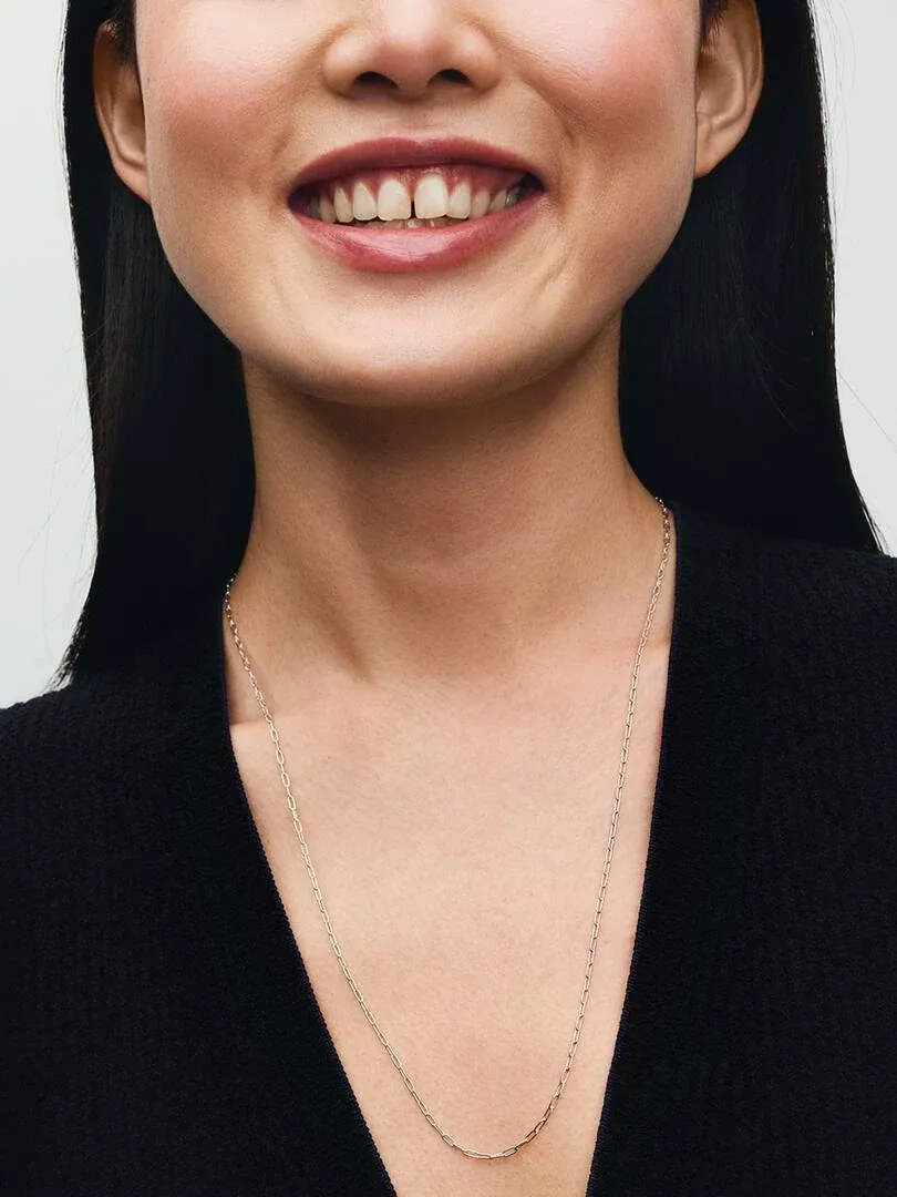 Close-up of link necklace on a model's neck, front view against a neutral background.