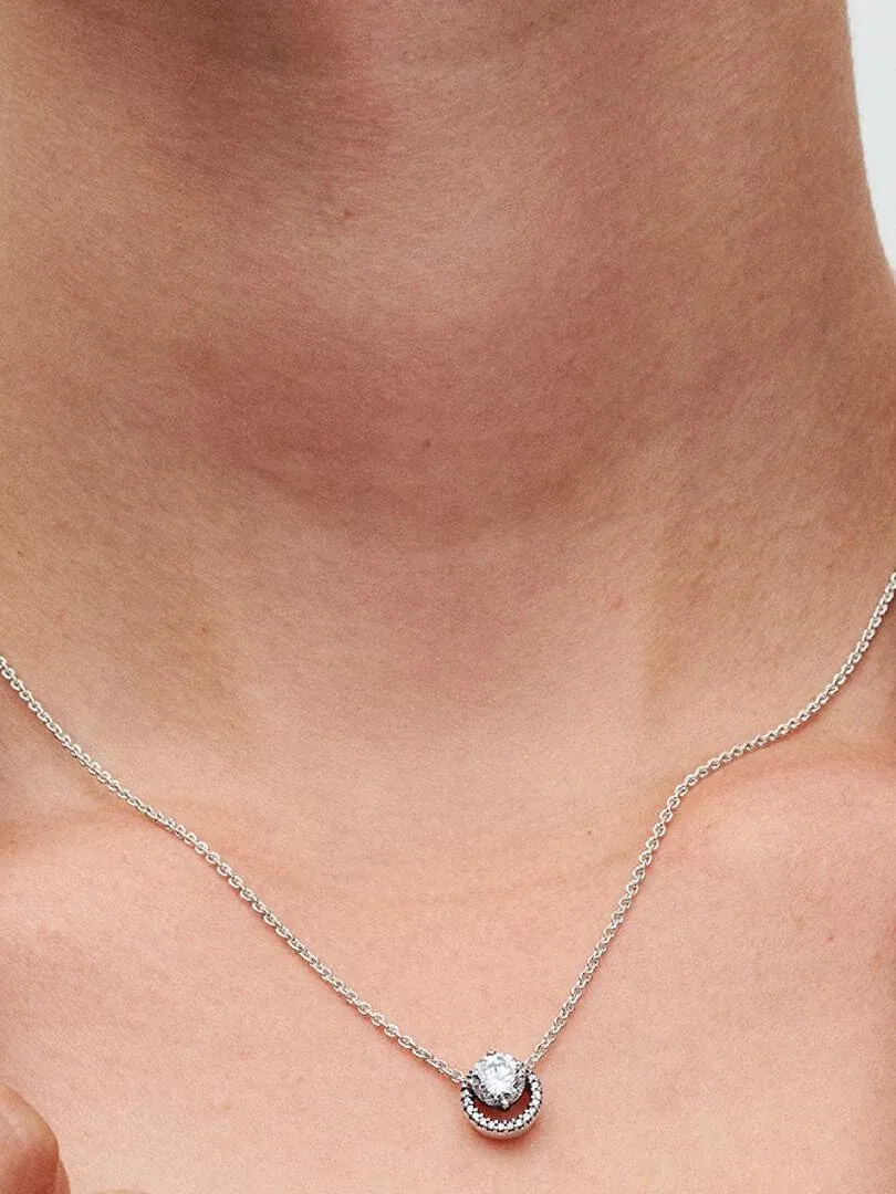 Gros plan du pendentif rond sur le cou d'un modèle, vue de face avec peau naturelle et fond flou.