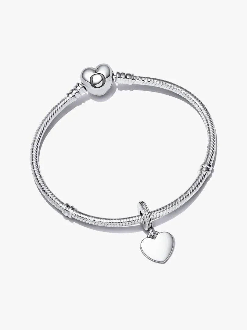 Pulsera de plata con cierre de corazón y charm colgante, vista frontal sobre fondo blanco.