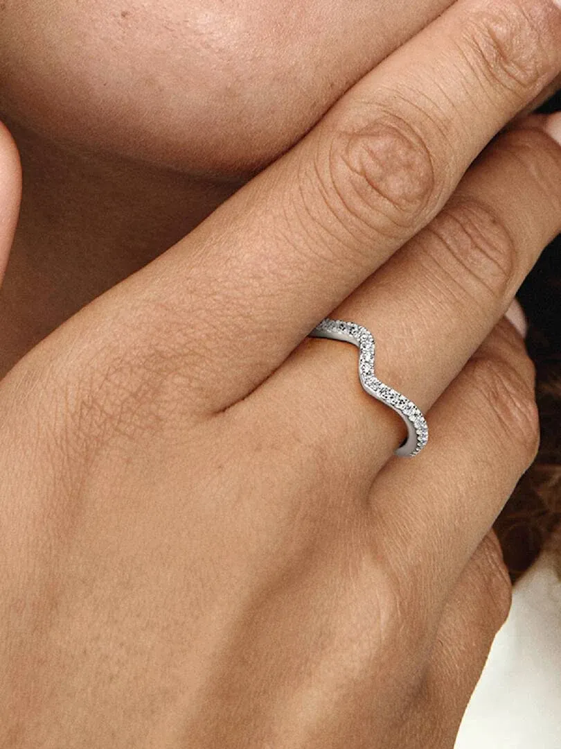 Primer plano del anillo ondulado con circonitas puesto en el dedo, toma lateral sobre la mano.