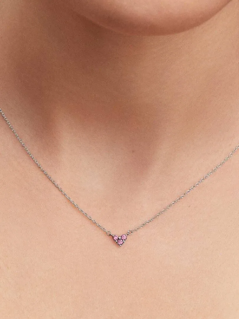 Close-up of the pink heart necklace on a model's neck, centered frontal shot.