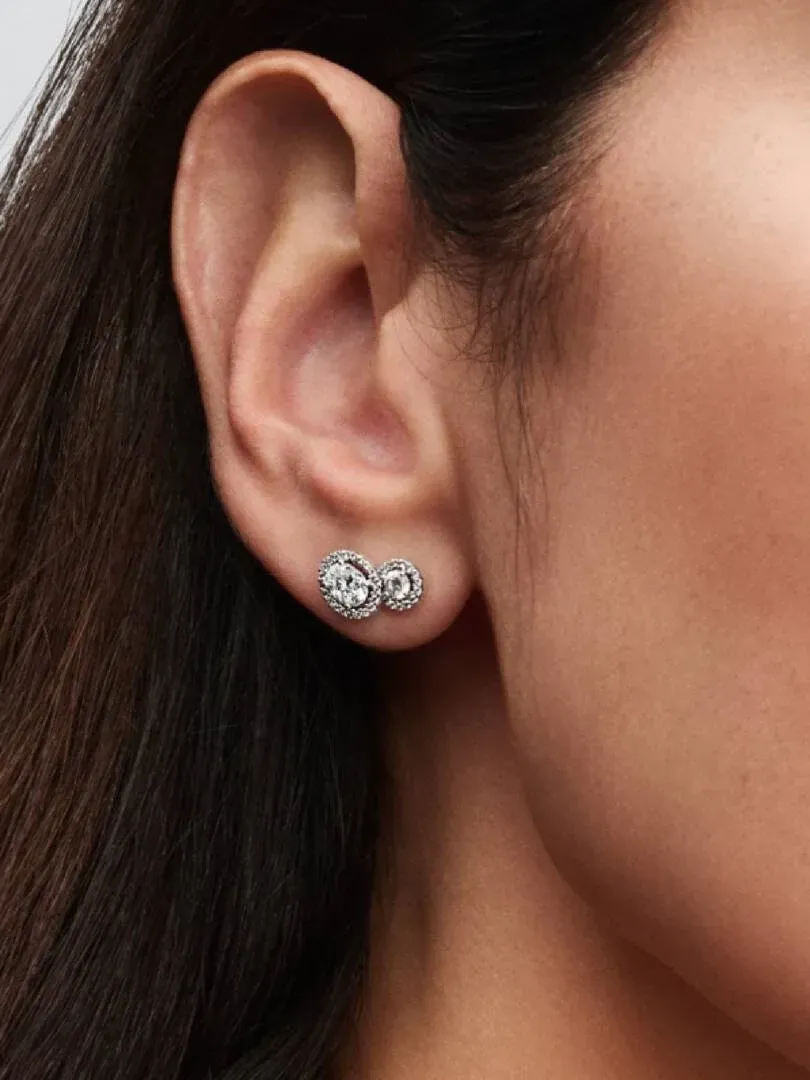 Close-up of stud earrings with cubic zirconia worn on the earlobe, side view.