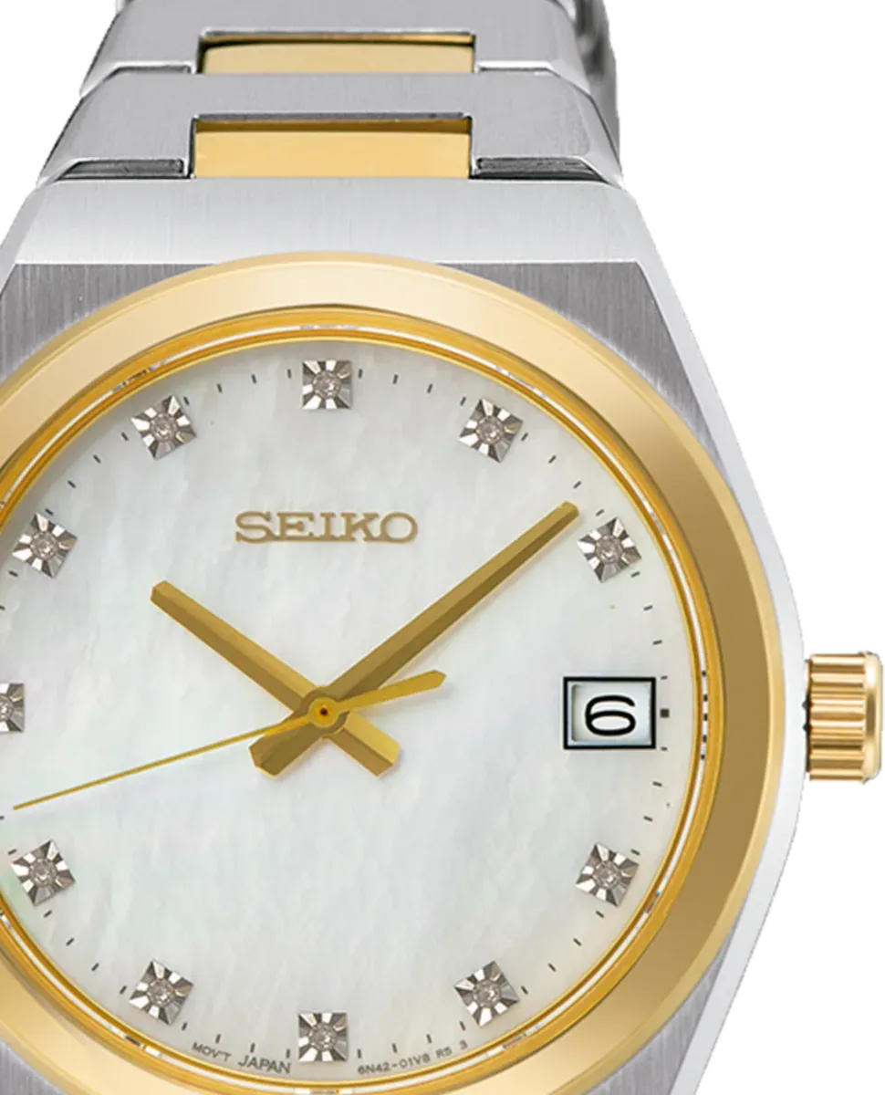 Primer plano de la esfera blanca con índices de diamante y bisel dorado, fondo blanco.
