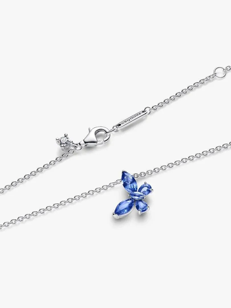 Gros plan du pendentif papillon bleu et du fermoir de la chaîne sur fond blanc.