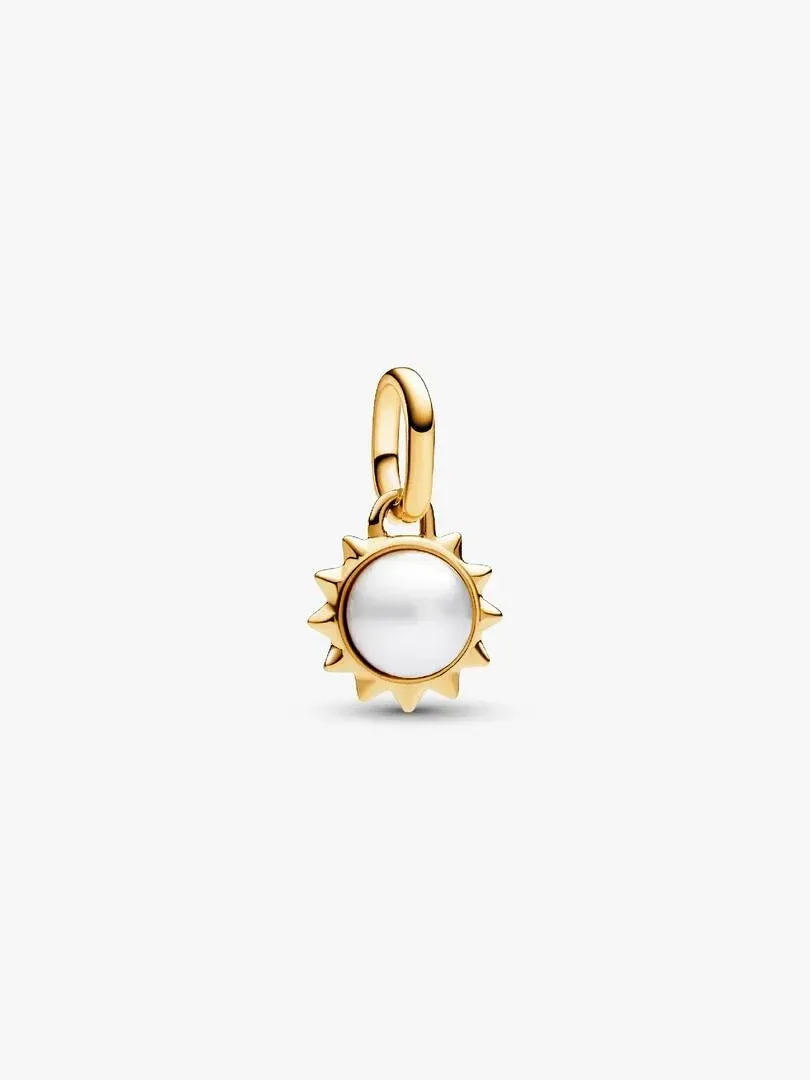 Sun charm with white pearl, front view, on a neutral white background.
