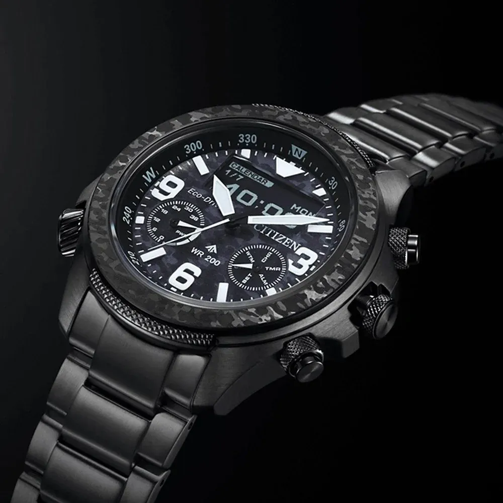Toma en perspectiva del reloj sobre fondo negro, detalle de la esfera y el bisel camuflado.