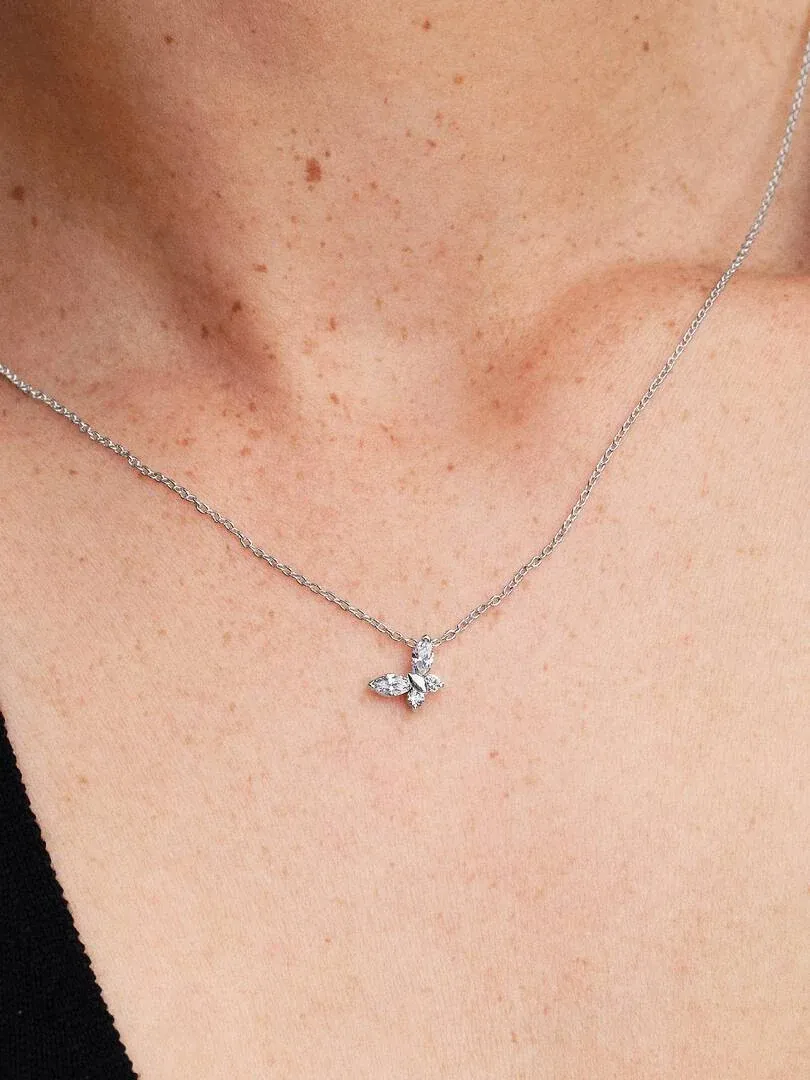 Gros plan du pendentif papillon avec zircons sur le cou d'un mannequin, vue de face.