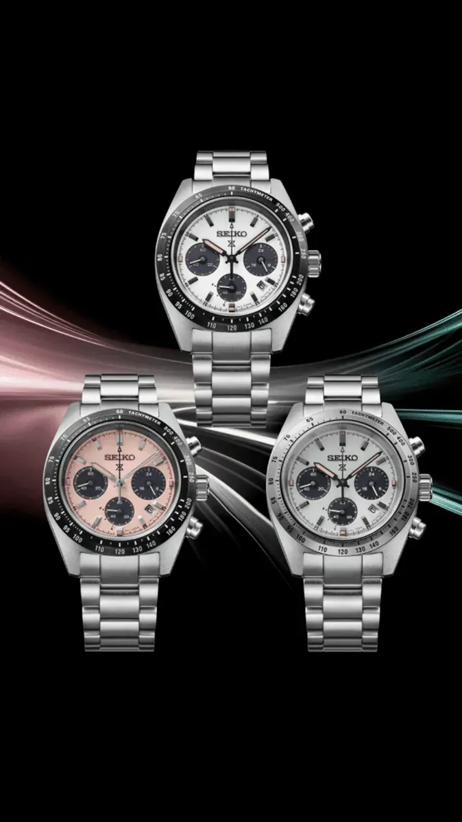 Composición de tres relojes sobre fondo negro con estelas de luz dinámicas en tonos rosa y verde.