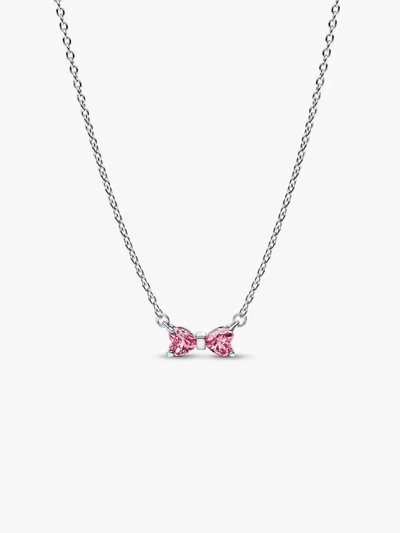 Silver necklace with pink bow pendant, front view on white background.