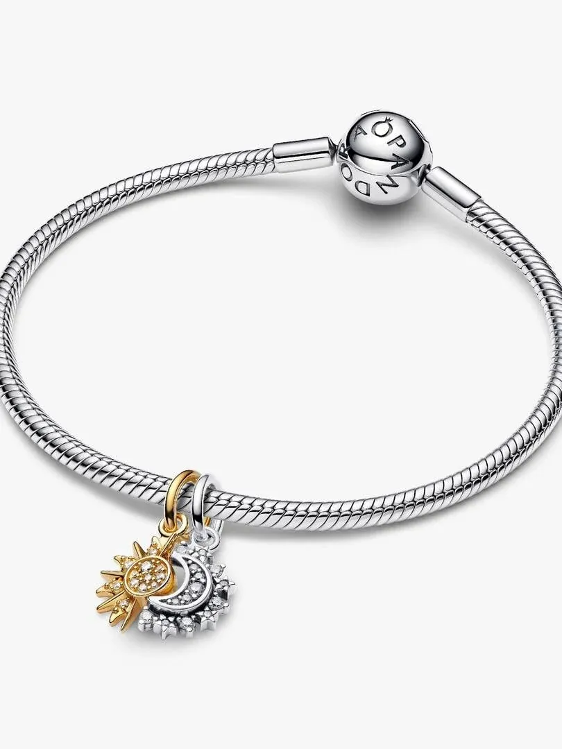 Charm soleil et lune suspendu à un bracelet en argent, vue de face sur fond blanc.