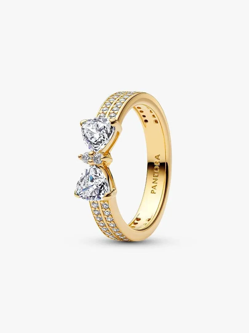 Anillo de doble banda con motivo de lazo y circonitas, vista lateral en ángulo sobre fondo blanco.