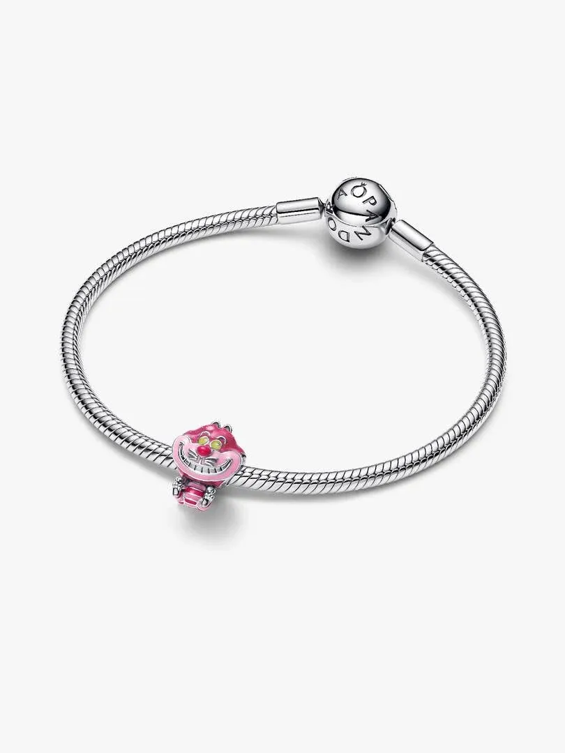 Charm de gato rosa sobre brazalete de plata, vista lateral en ángulo, fondo blanco.