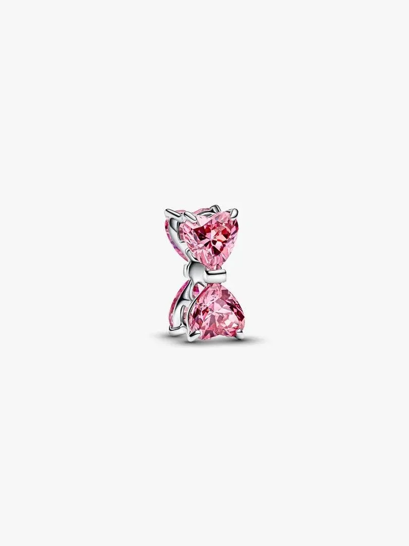 Zijweergave van roze cubic zirconia strik charm op een witte achtergrond.