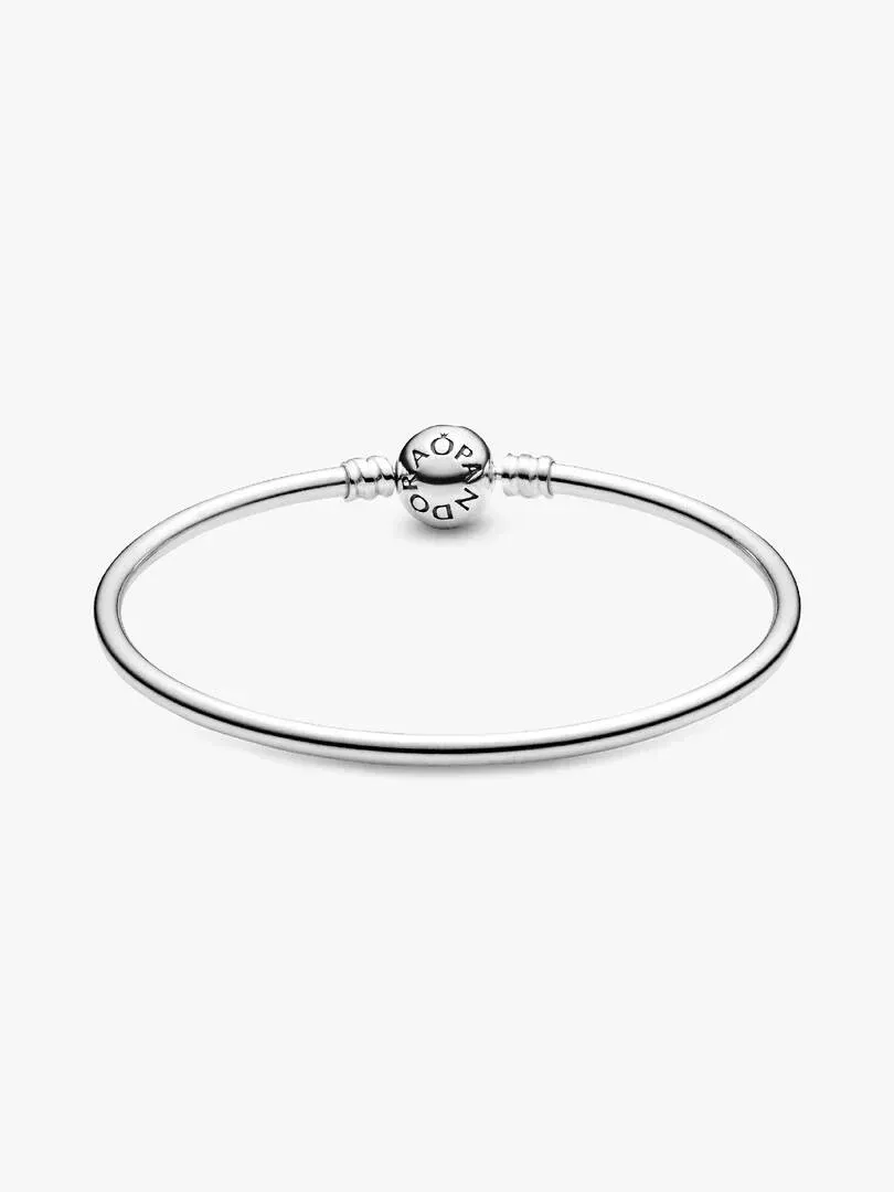 Pulsera rígida de plata vista en ángulo frontal, sobre fondo blanco, destacando el cierre esférico con logotipo.