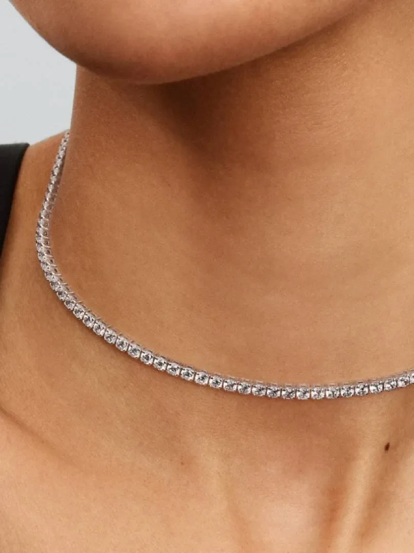 Gros plan du choker en zircons sur le cou d'un mannequin, vue de profil sur fond neutre.