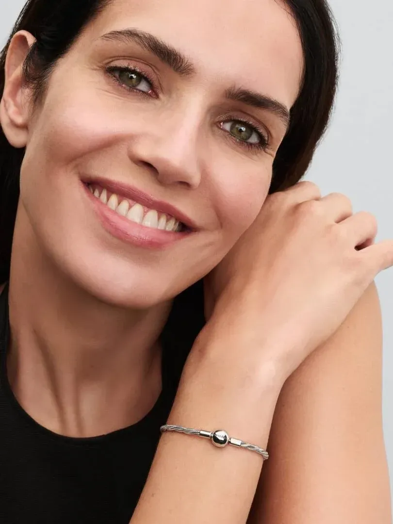 Primer plano de la pulsera en la muñeca de una modelo, toma lateral con fondo desenfocado.