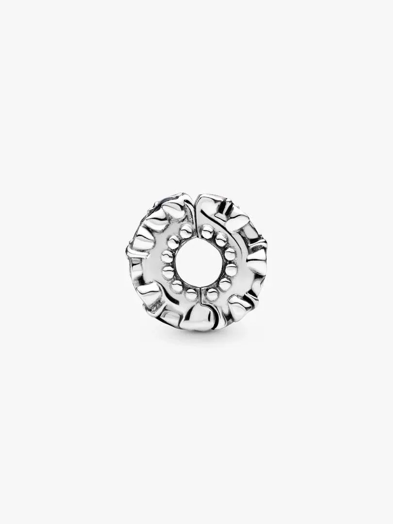 Clip charm viewed from a side angle, white background, detail of the silver butterfly relief.