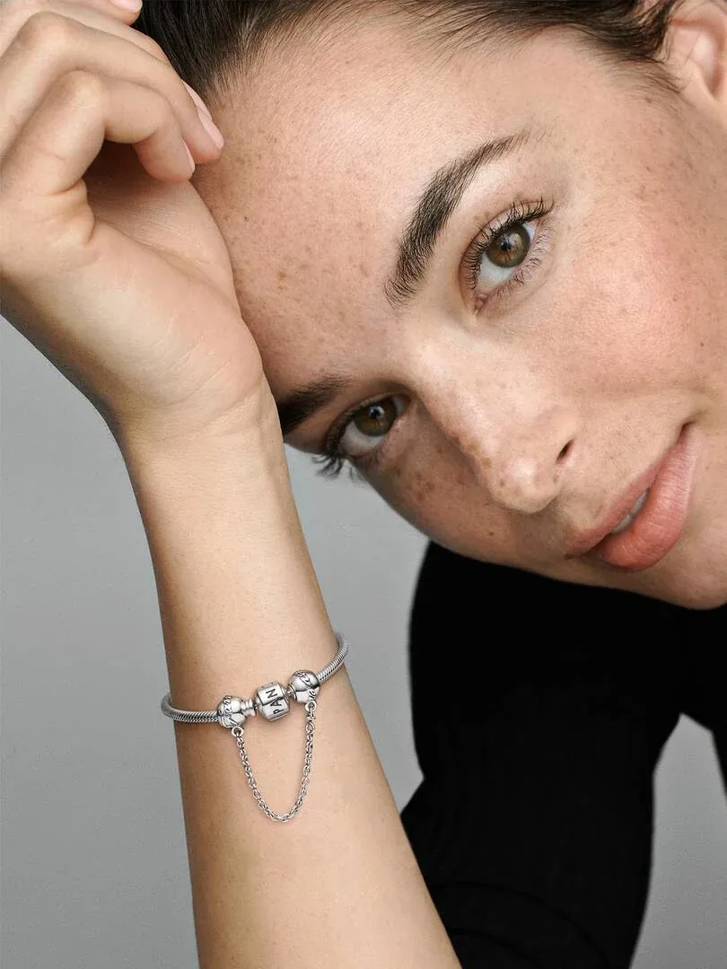 Gros plan du bracelet au poignet, vue de profil avec modèle sur fond gris neutre.