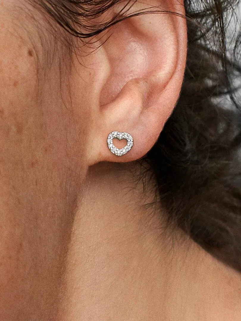 Close-up van hartvormige oorbel met zirkonia gedragen aan het oorlel, zijaanzicht.