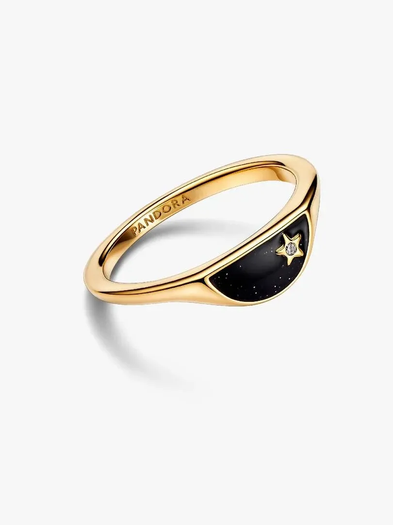 Anillo tipo sello visto en ángulo lateral sobre fondo blanco, detalle del esmalte negro y la estrella central.