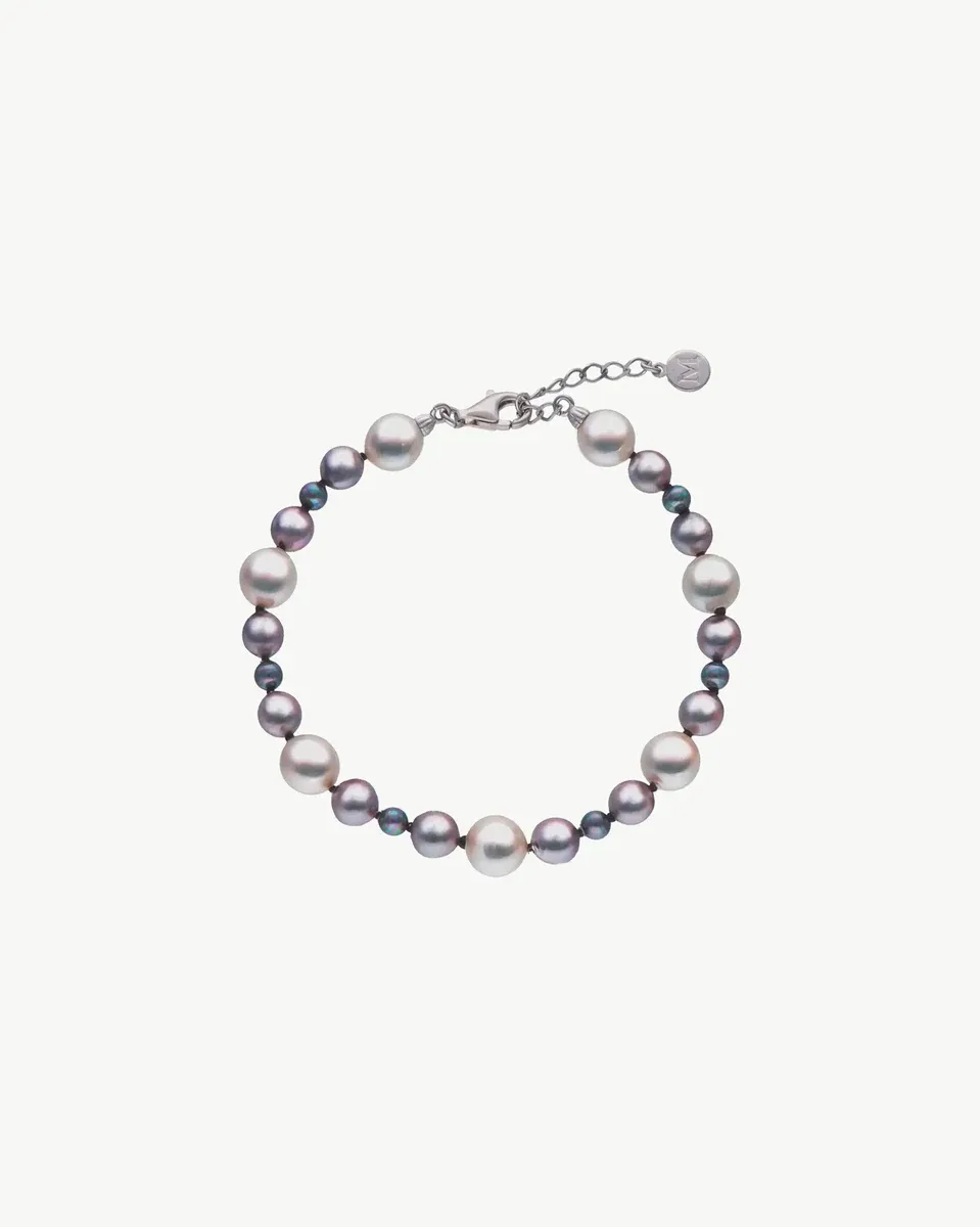 Pulsera de perlas dispuesta en círculo sobre fondo blanco, vista cenital con detalle del cierre de plata.