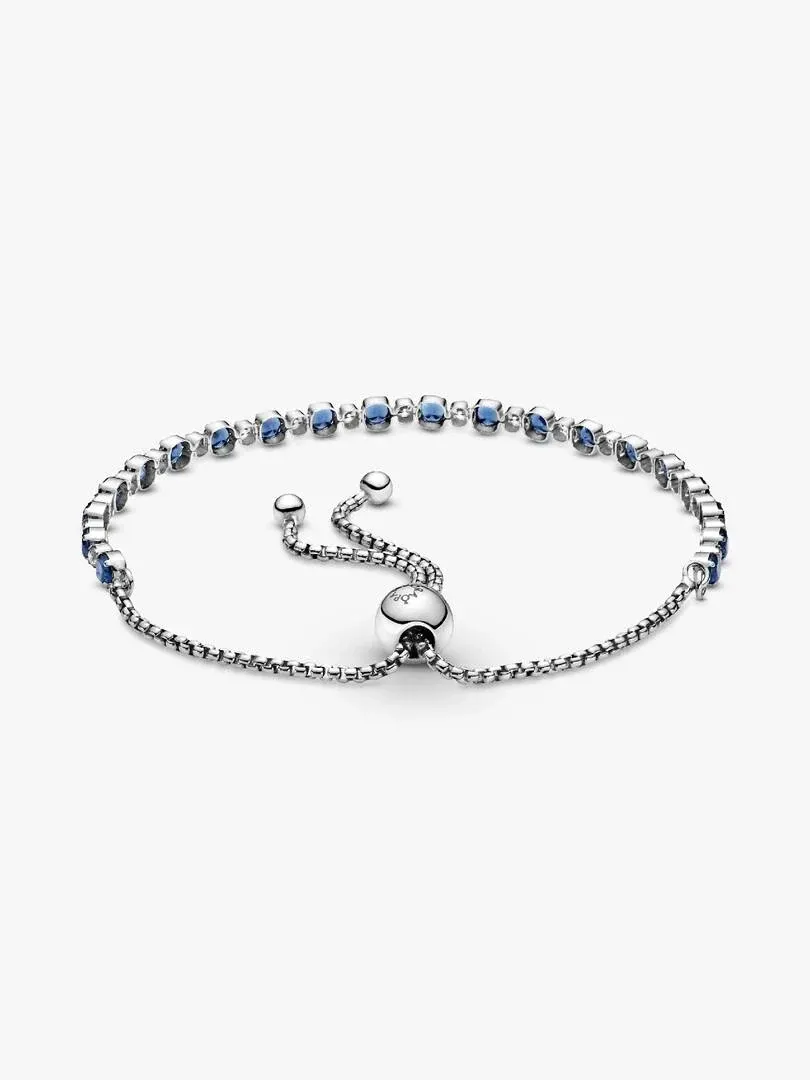 Bracelet en argent avec pierres bleues et transparentes, vue de face inclinée sur fond blanc.