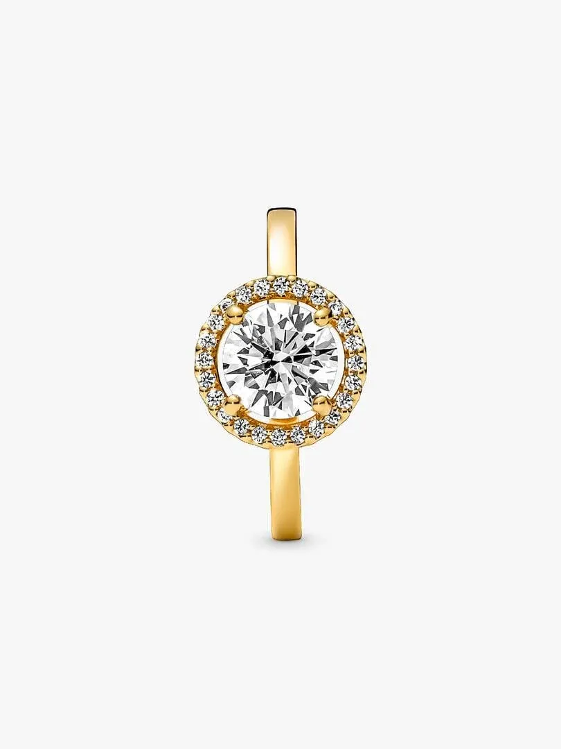 Anillo visto de frente en ángulo vertical, gema central con halo de circonitas sobre fondo blanco.