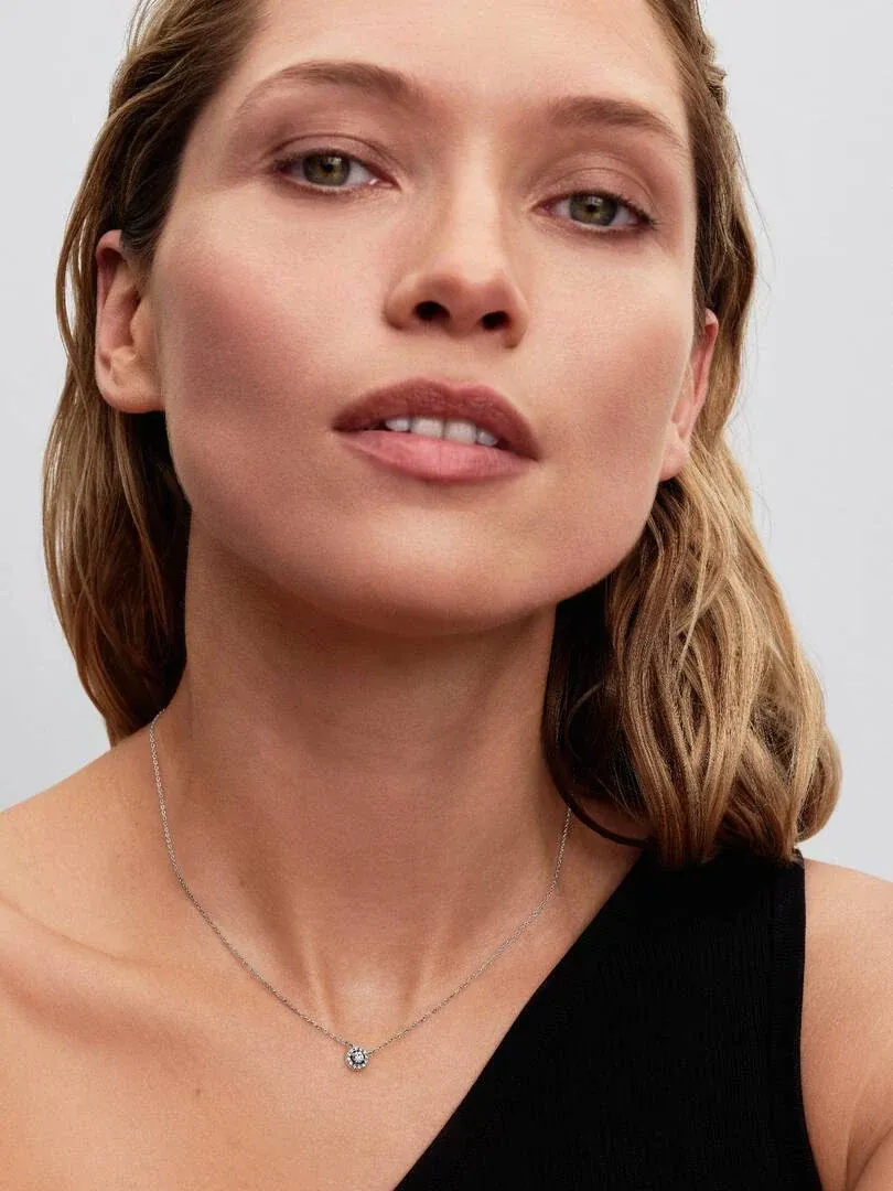 Gros plan du pendentif en zircons sur le cou d'un mannequin, vue de face sur fond neutre.