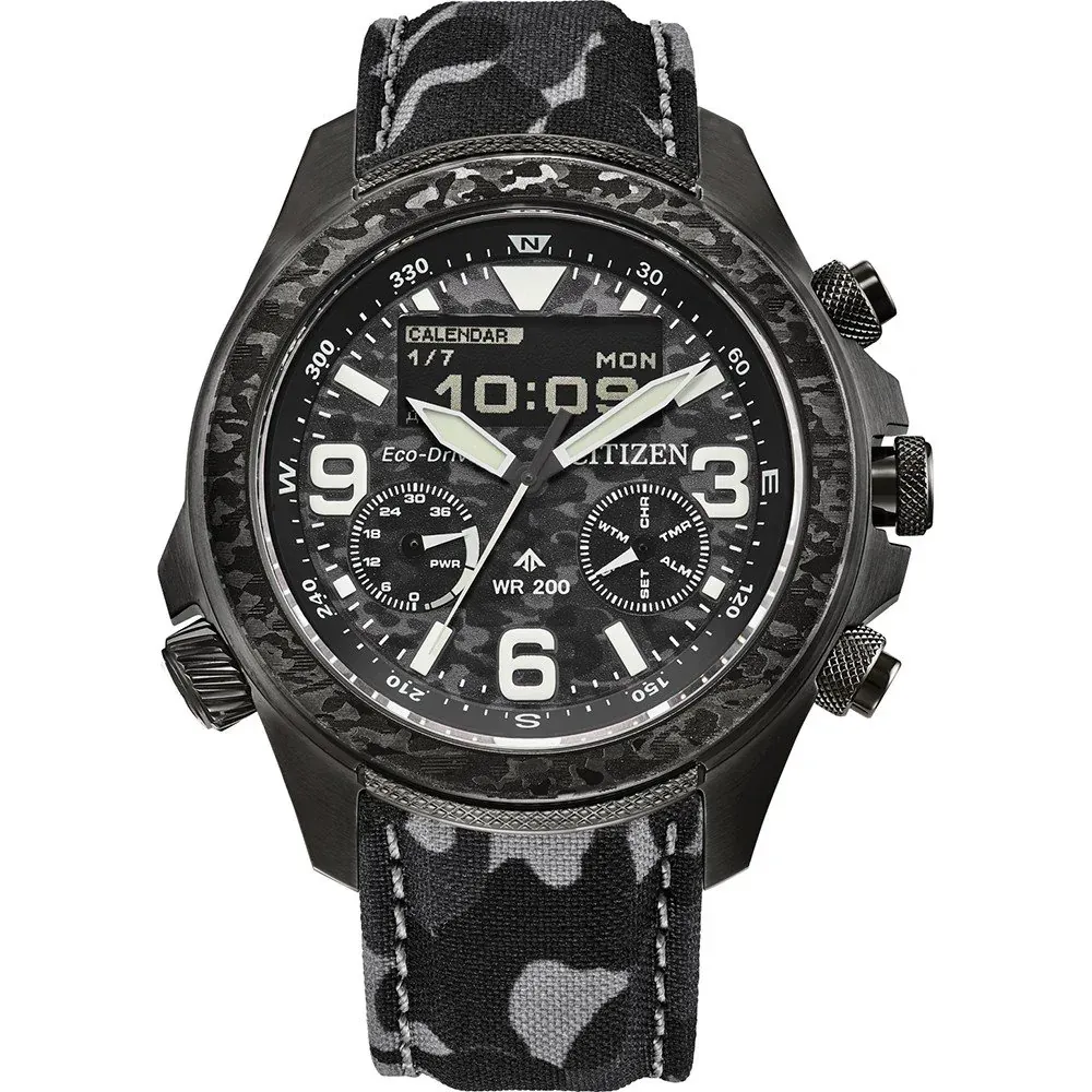Vista frontal del reloj con correa textil camuflada sobre fondo blanco.