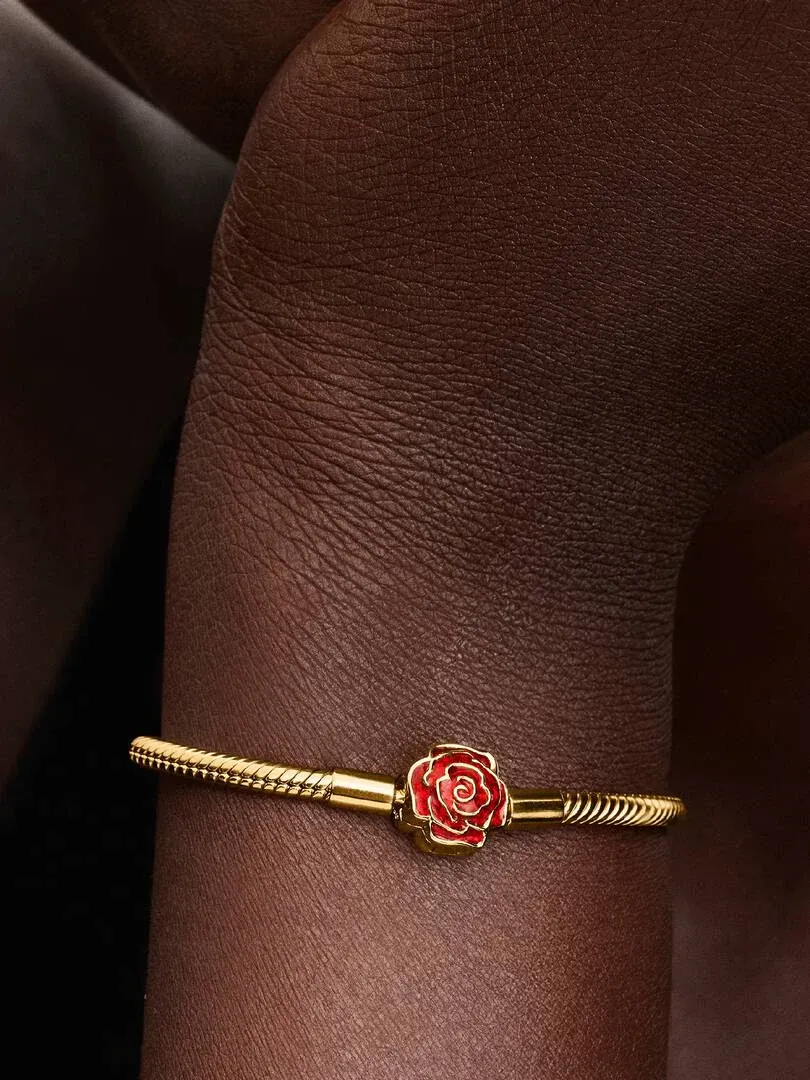 Close-up van de armband met rode rozen sluiting om een pols, zijaanzicht tegen een donkere achtergrond.