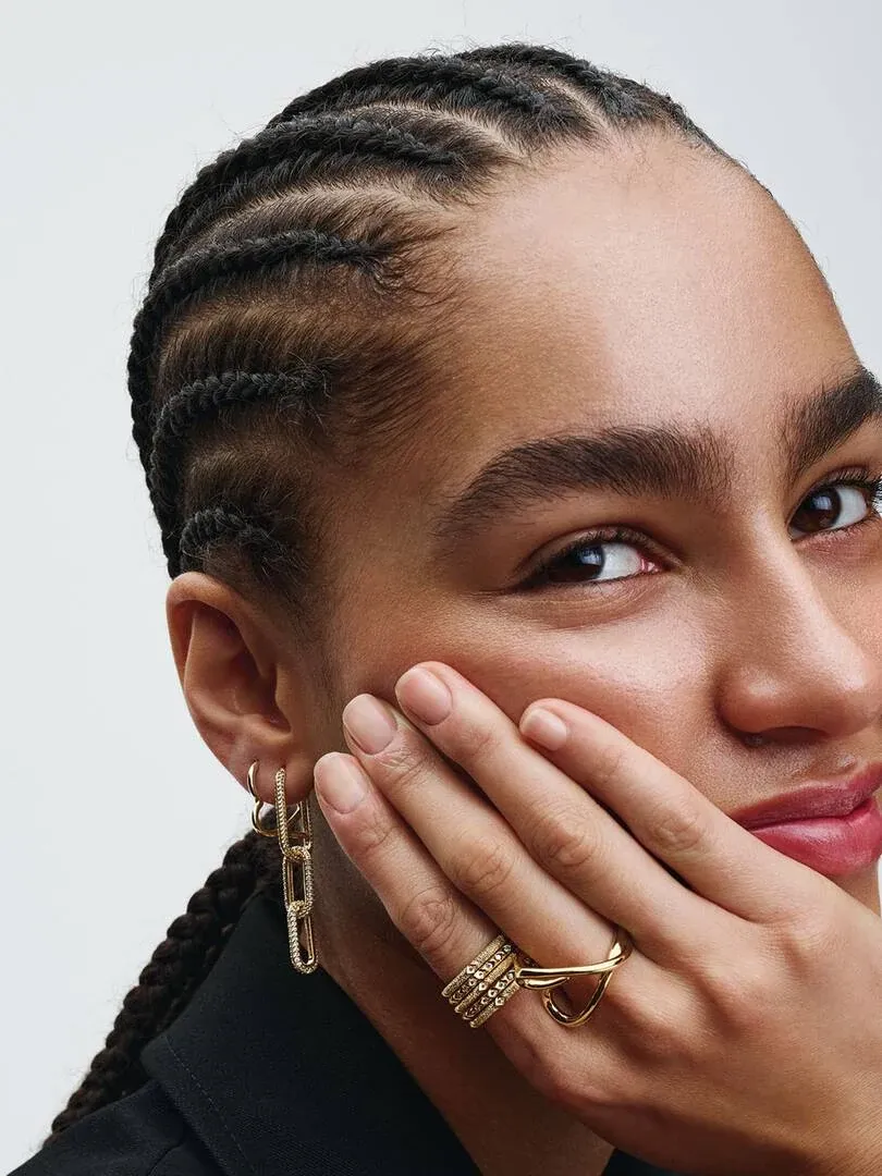 Close-up of gold rectangular pavé hoop earring worn on ear, side view with model.