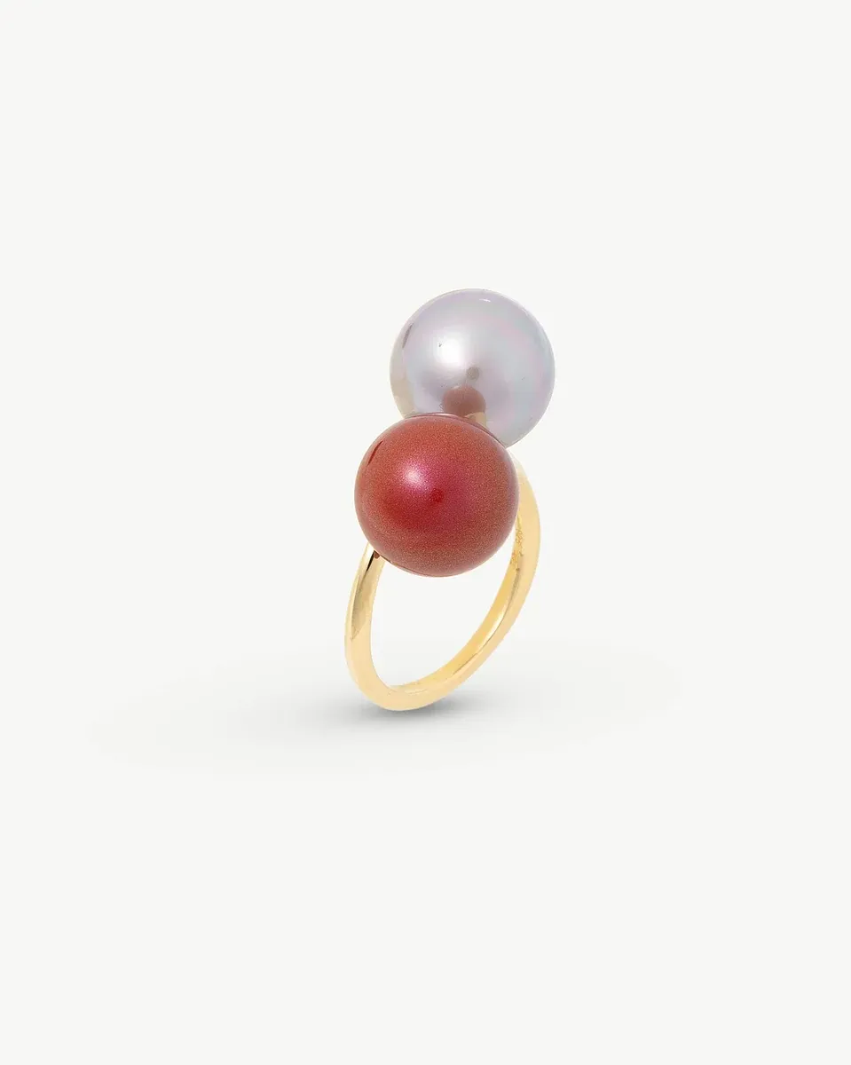 Side angle view of the pearl ring on a white background, highlighting the red and nuage pearl combination.