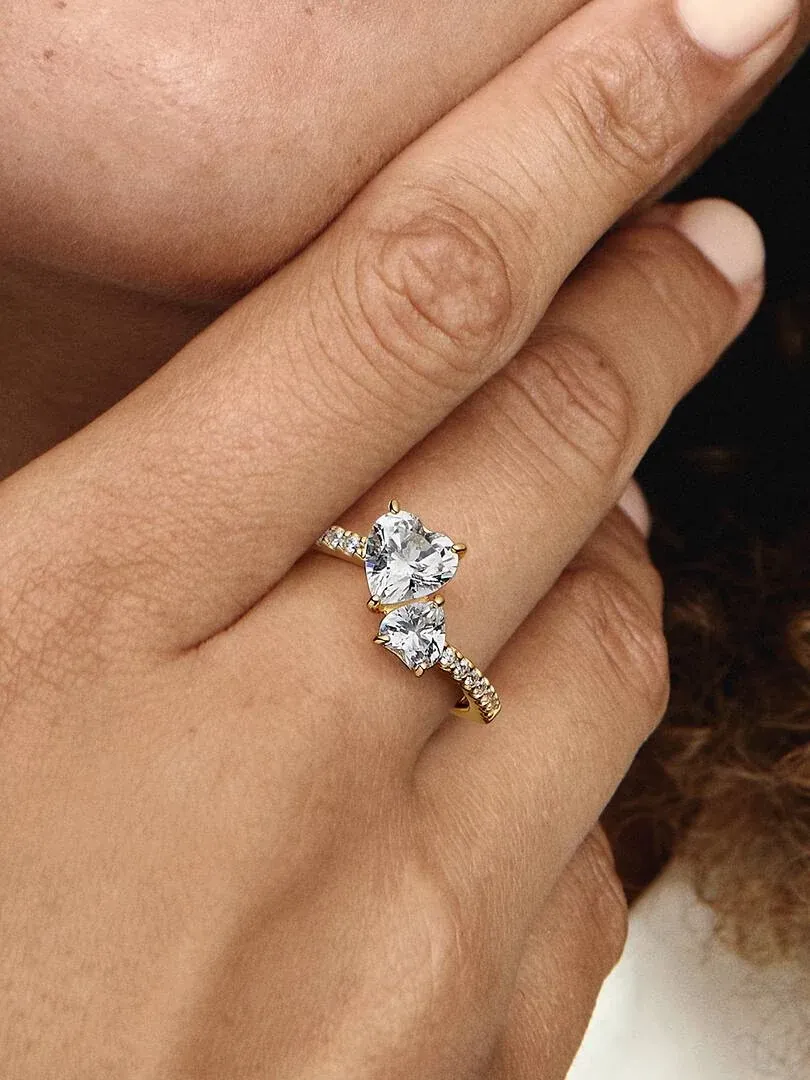 Primer plano del anillo de corazón doble puesto en un dedo, toma lateral con fondo desenfocado.