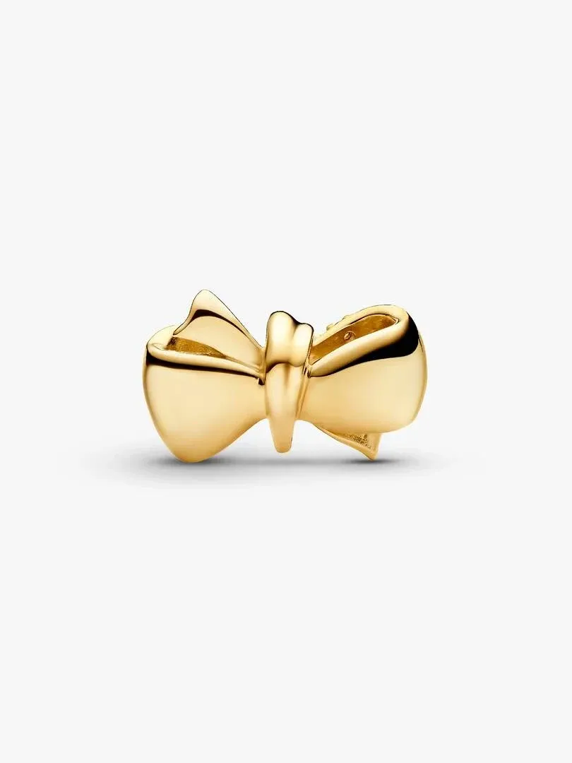 Gold bow charm front view, slightly high angle, isolated on a pure white background.