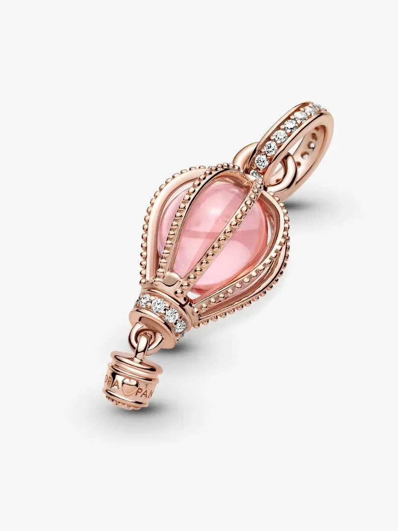 Charm ballon en or rose avec cristal rose, vue latérale diagonale sur fond blanc.