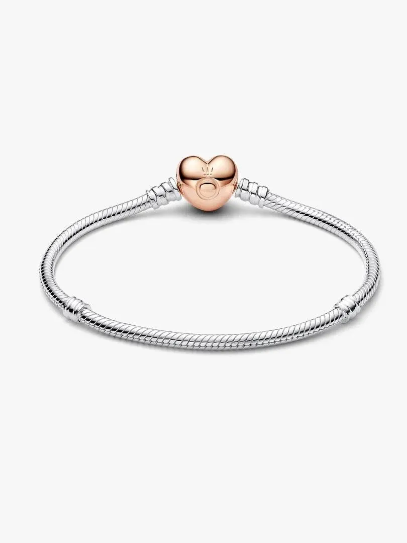 Pulsera de cadena de serpiente vista frontalmente en ángulo, con cierre de corazón en oro rosa sobre fondo blanco.