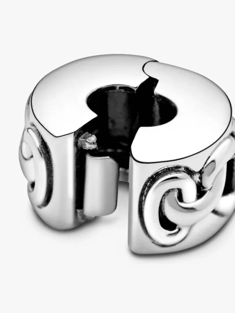 Close-up of the silver clip charm with heart motifs, high-angle shot on a white background.