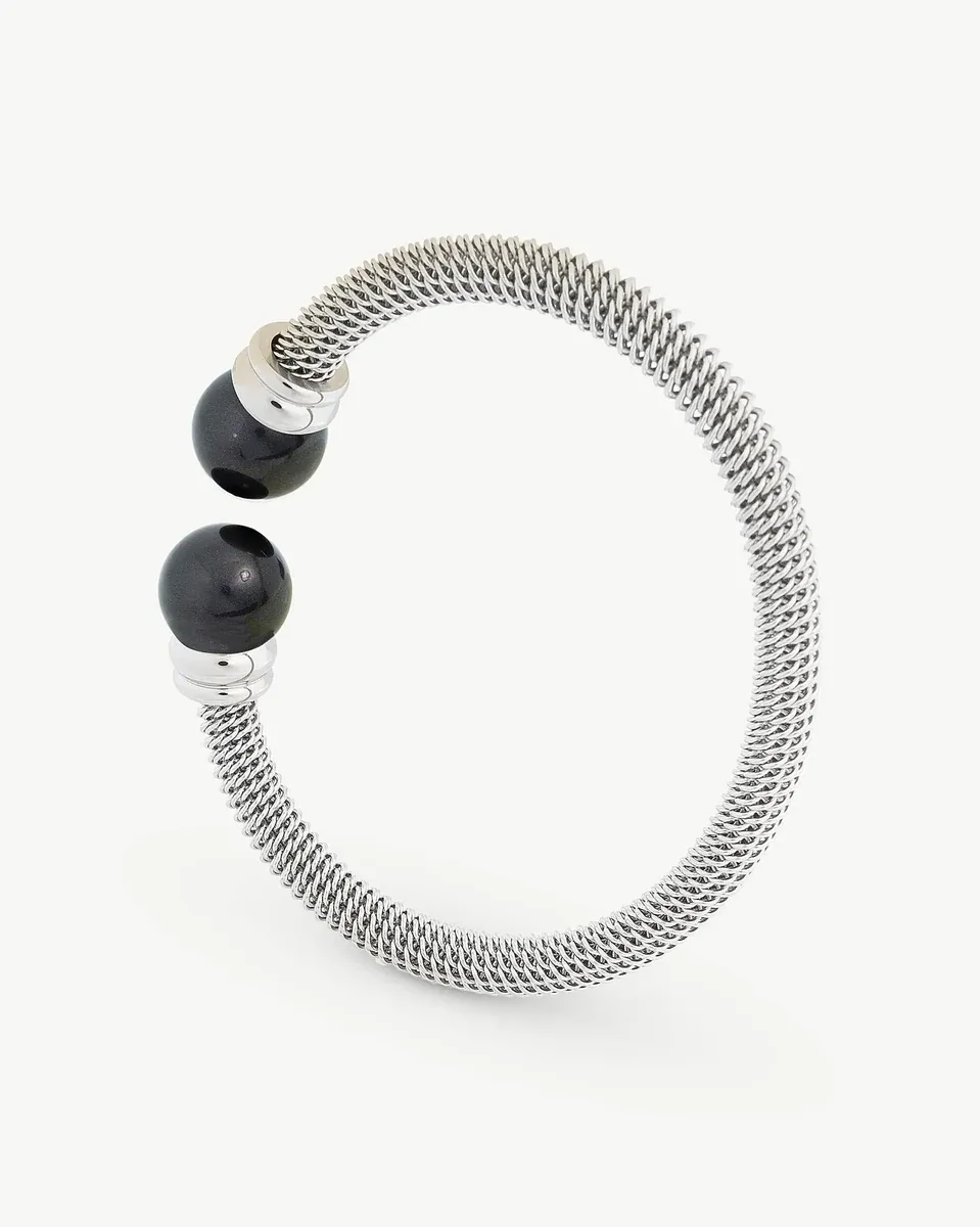 Bracelet jonc en acier avec deux perles noires, vue de profil sur fond blanc.