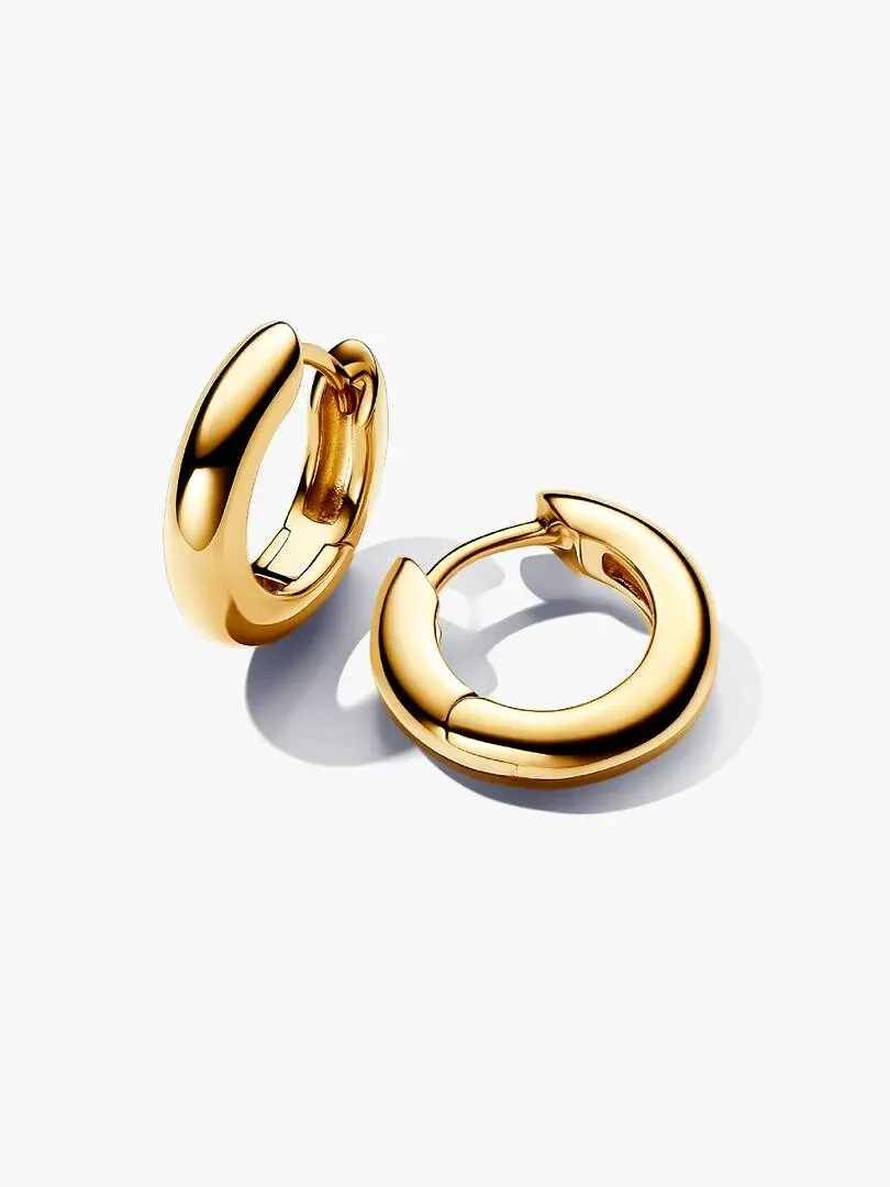 Paar goldfarbene Creolen mit abgerundetem Profil, Winkelansicht auf weißem Hintergrund.