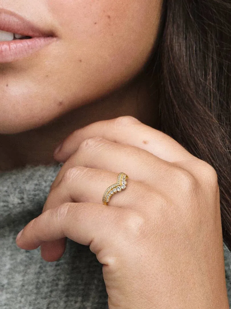 Primer plano del anillo tipo tiara en el dedo anular, toma lateral sobre mano con fondo desenfocado.