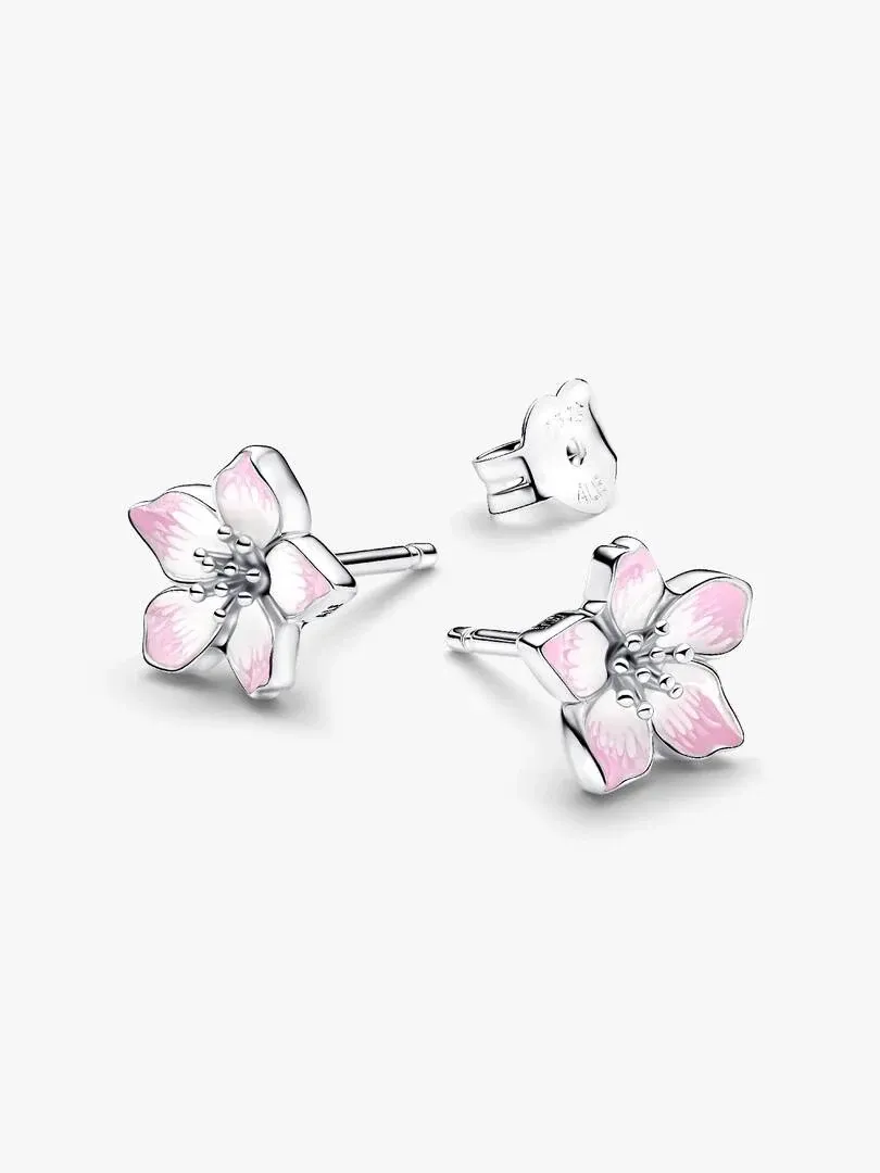 Paire de boucles d'oreilles fleur avec émail rose, vue de face sur fond blanc neutre.
