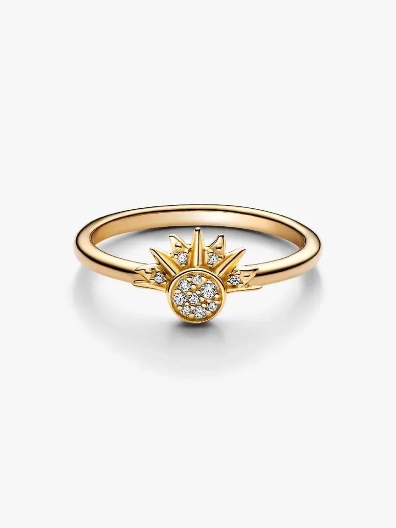 Anillo con motivo de sol visto en ángulo lateral, fondo blanco, detalle del diseño con circonitas.