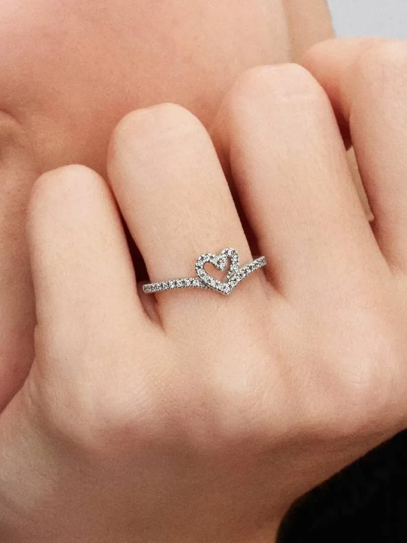 Close-up of the heart-shaped ring on a ring finger, side view on skin.