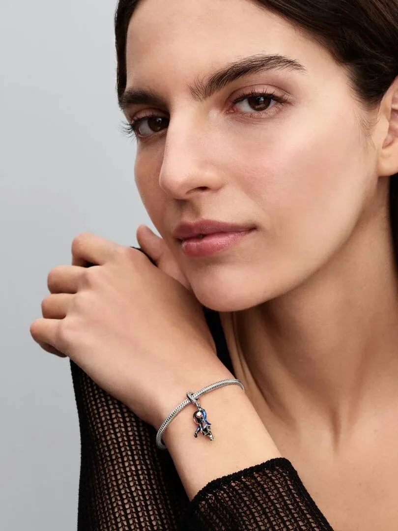 Gros plan du poignet avec le charm Spider-Man, vue de profil sur fond neutre.